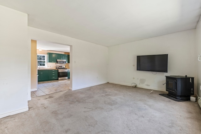 unfurnished living room featuring light carpet and a wood stove