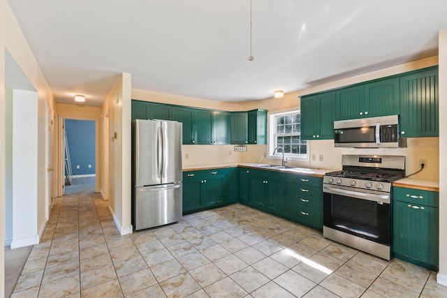 kitchen featuring stainless steel appliances, green cabinetry, and sink