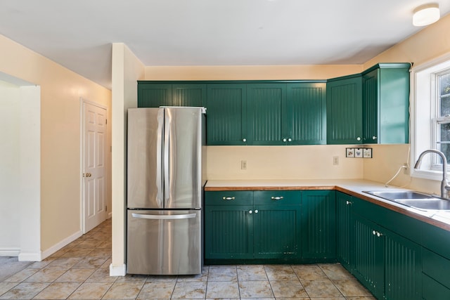 kitchen with stainless steel refrigerator and green cabinetry