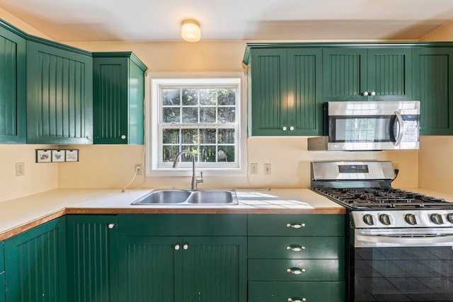 kitchen featuring green cabinetry, stainless steel appliances, and sink