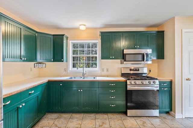 kitchen with light tile patterned floors, green cabinetry, stainless steel appliances, and sink