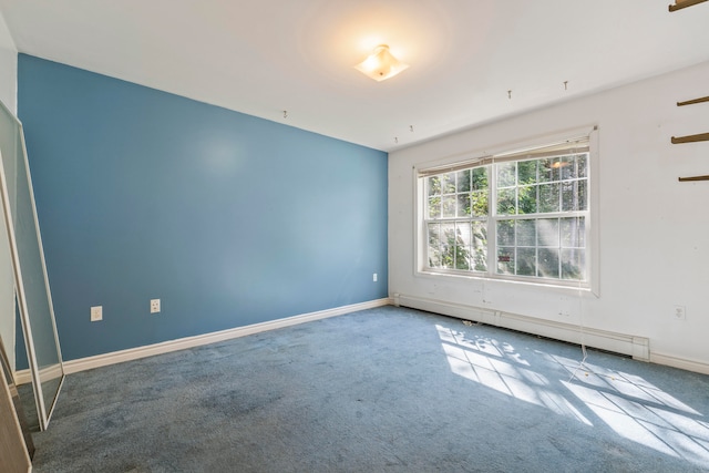 carpeted spare room with a baseboard heating unit