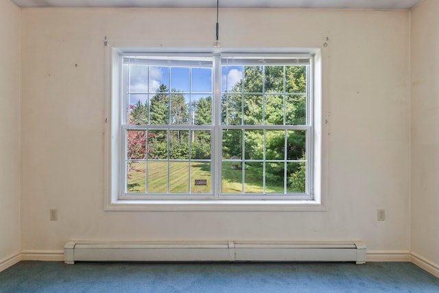 carpeted empty room featuring a baseboard heating unit