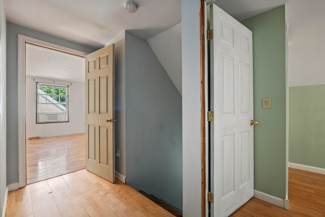 hall featuring lofted ceiling and light hardwood / wood-style flooring