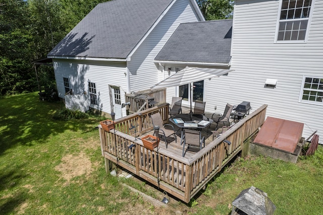 back of property with a wooden deck and a lawn