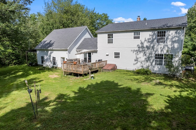 rear view of property featuring a deck and a yard