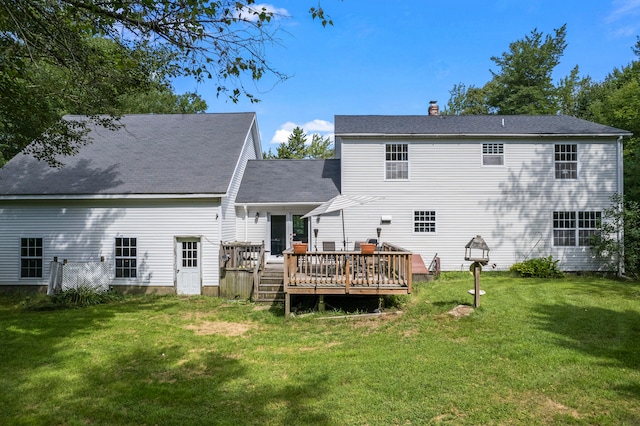 rear view of property with a deck and a yard