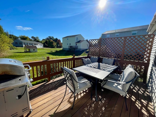 wooden deck with grilling area and a yard