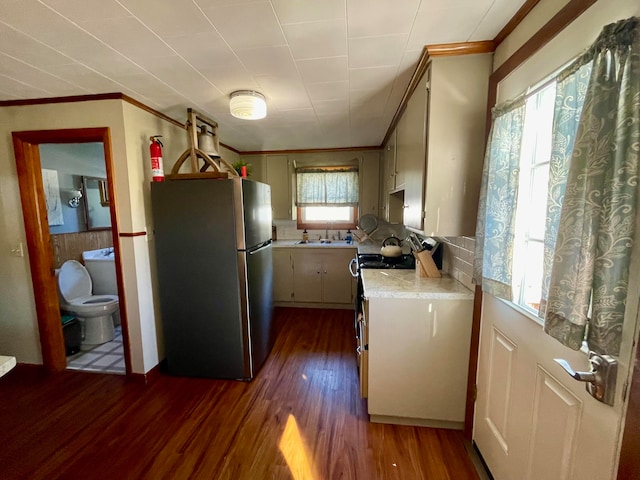 kitchen with stainless steel fridge, sink, dark wood-type flooring, white range, and crown molding