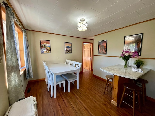 dining space featuring crown molding and dark hardwood / wood-style flooring