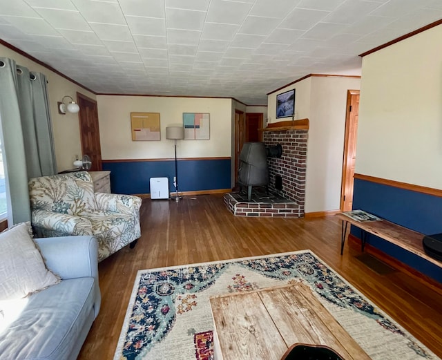 living room with crown molding, dark hardwood / wood-style flooring, and a wood stove