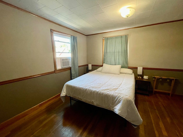 bedroom featuring cooling unit, crown molding, and dark wood-type flooring