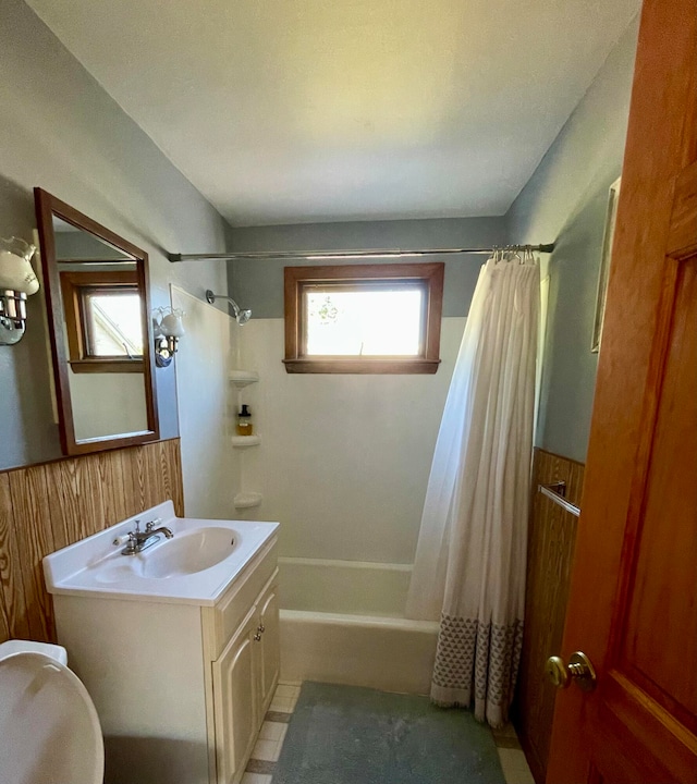 bathroom featuring shower / bath combination with curtain, vanity, and wooden walls