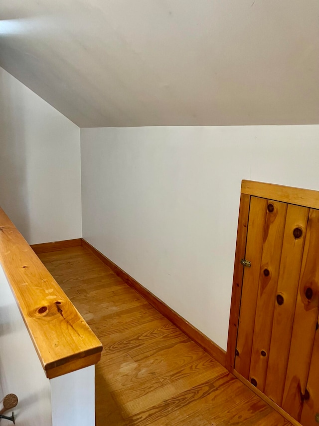 bonus room with light wood-type flooring and lofted ceiling