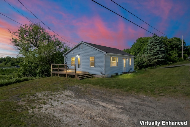 property exterior at dusk featuring a deck and a yard