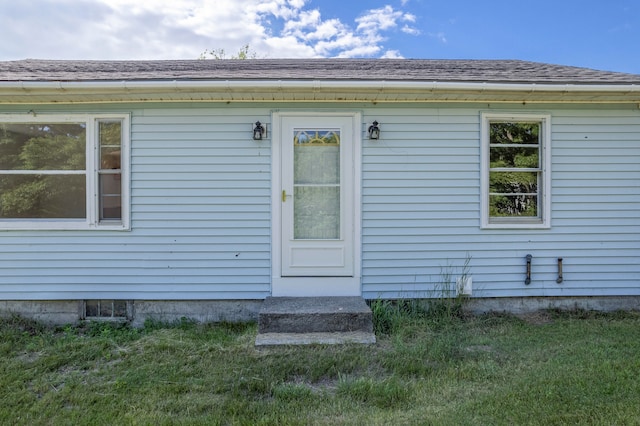 view of exterior entry with a lawn