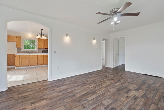 interior space with ceiling fan with notable chandelier, light wood-type flooring, and sink