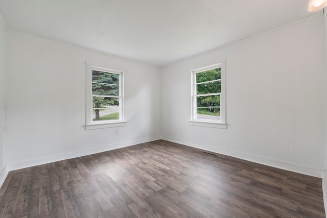 spare room featuring plenty of natural light, dark hardwood / wood-style flooring, and crown molding