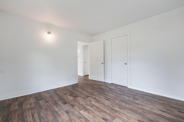 unfurnished room featuring ornamental molding and dark hardwood / wood-style flooring