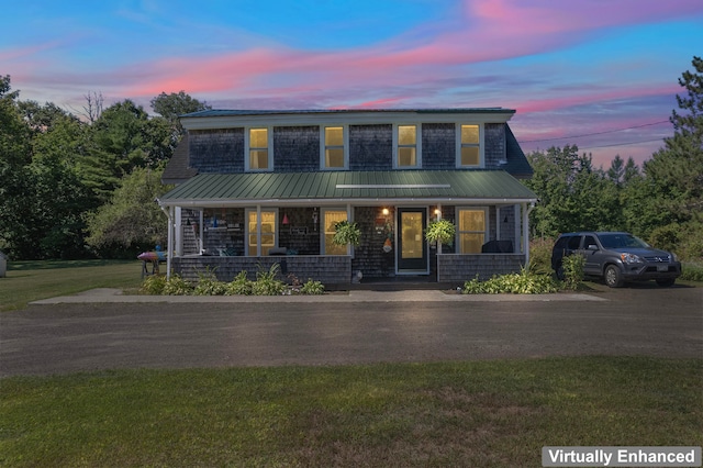 view of front of property with a porch and a yard