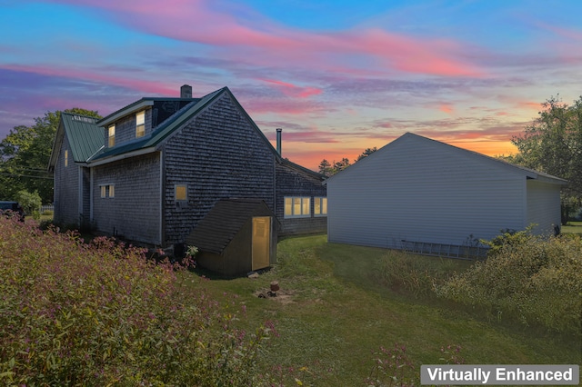 property exterior at dusk featuring a yard