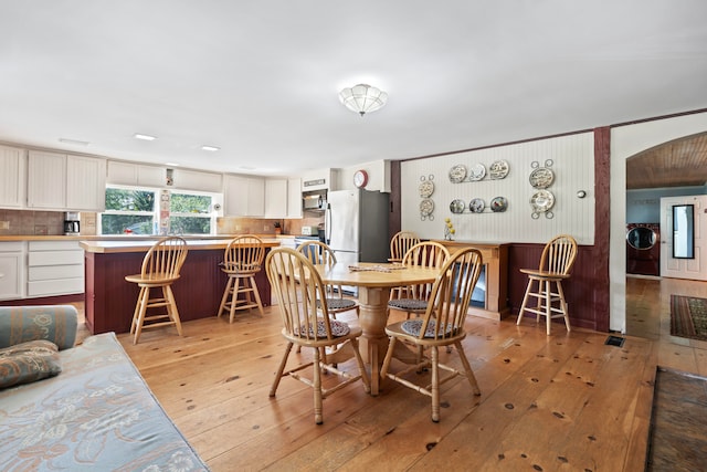 dining area with light wood-type flooring and washer / clothes dryer