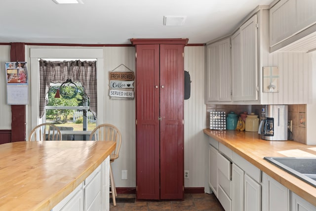 kitchen featuring butcher block countertops, sink, and white cabinetry