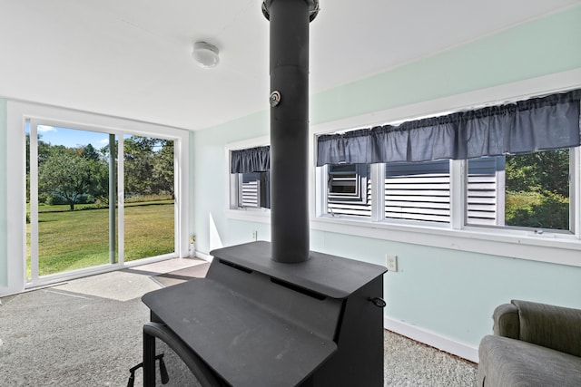 interior space featuring light colored carpet and a wood stove