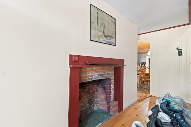 interior space featuring light wood-type flooring, a fireplace, and lofted ceiling