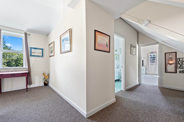 corridor featuring carpet floors and vaulted ceiling