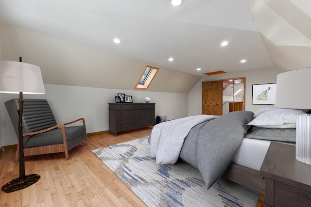 bedroom with light wood-type flooring and vaulted ceiling with skylight