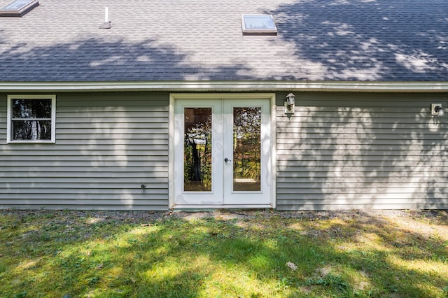 doorway to property featuring a lawn and french doors