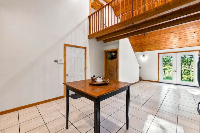 interior space featuring a high ceiling, light tile patterned floors, and french doors