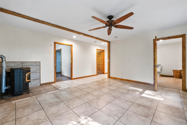 unfurnished living room featuring light tile patterned floors, ceiling fan, and a wood stove