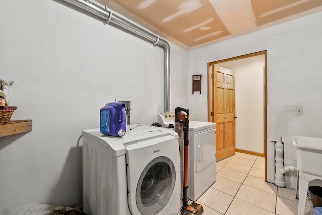 clothes washing area featuring independent washer and dryer and light tile patterned floors