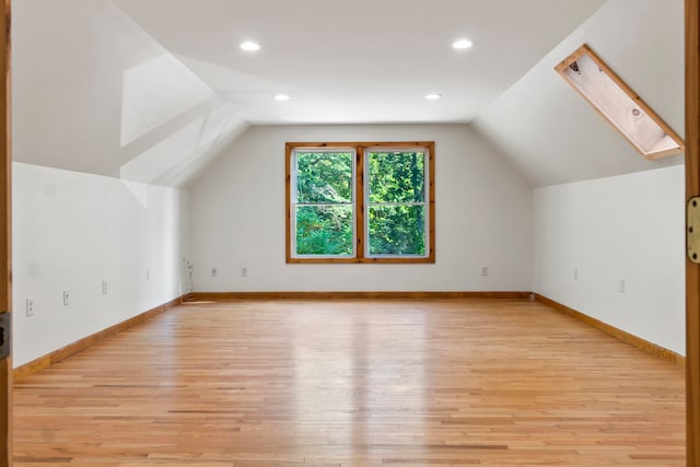 bonus room featuring light wood-type flooring and vaulted ceiling