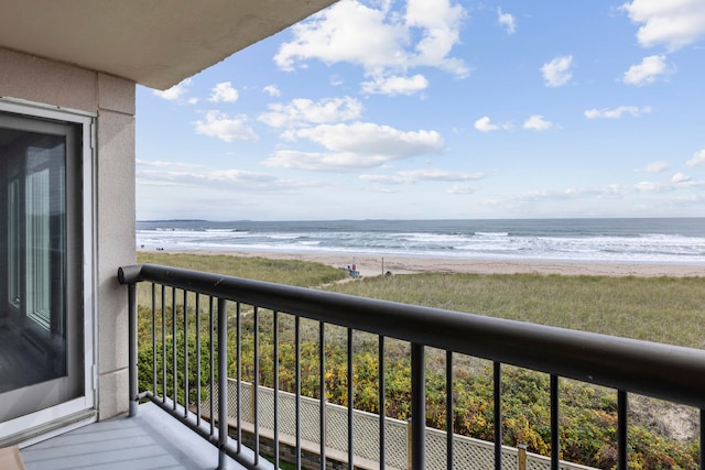 balcony featuring a water view and a beach view