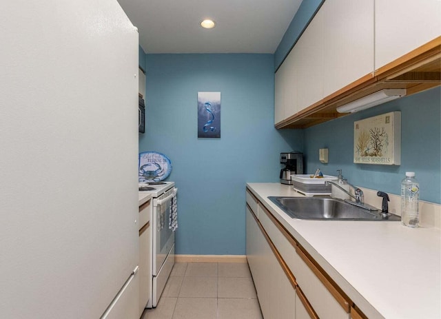 kitchen with white appliances, sink, light tile patterned floors, and white cabinets