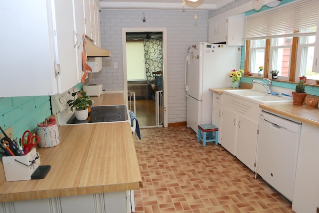 kitchen with white appliances, sink, and white cabinets