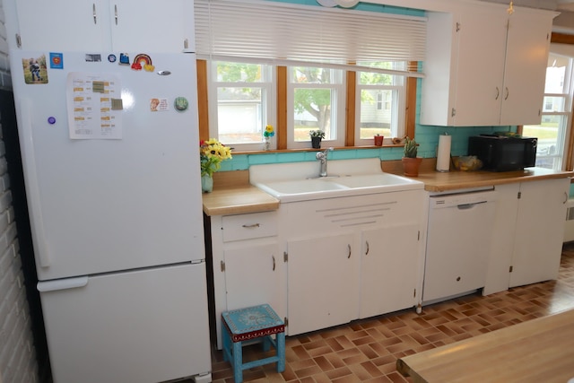 kitchen featuring a healthy amount of sunlight, white appliances, and white cabinets