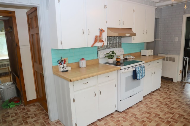 kitchen with custom range hood, tasteful backsplash, white electric range, and white cabinetry