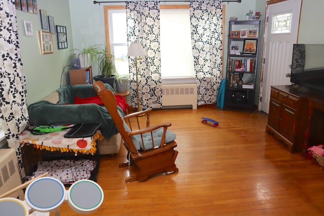 living room with hardwood / wood-style flooring, radiator, and a wealth of natural light