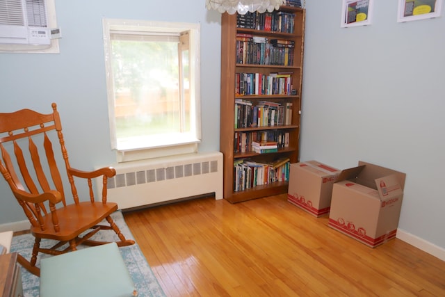 sitting room with light hardwood / wood-style floors, radiator heating unit, and a wealth of natural light