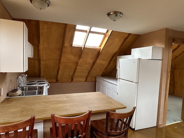 kitchen featuring white cabinetry, white appliances, lofted ceiling with skylight, dark hardwood / wood-style floors, and sink