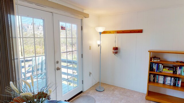 entryway with ornamental molding, a wealth of natural light, and french doors