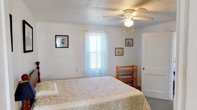 carpeted bedroom with crown molding and ceiling fan