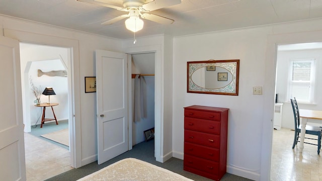 bedroom with ceiling fan, ornamental molding, and a closet