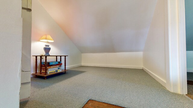 bonus room featuring vaulted ceiling and carpet