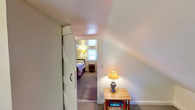 hallway with carpet and lofted ceiling