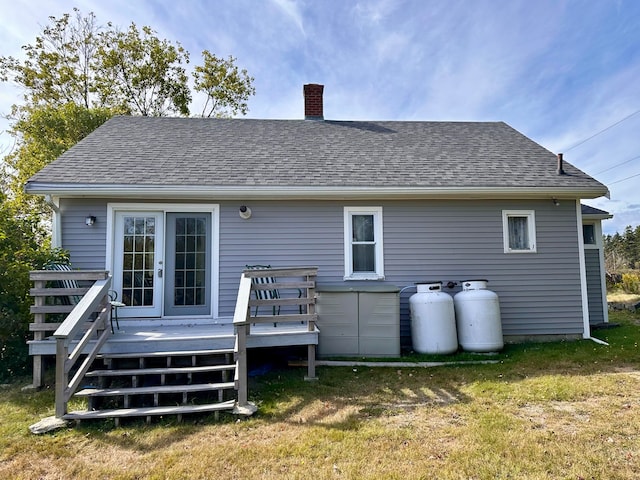 rear view of property with a lawn, a deck, and french doors